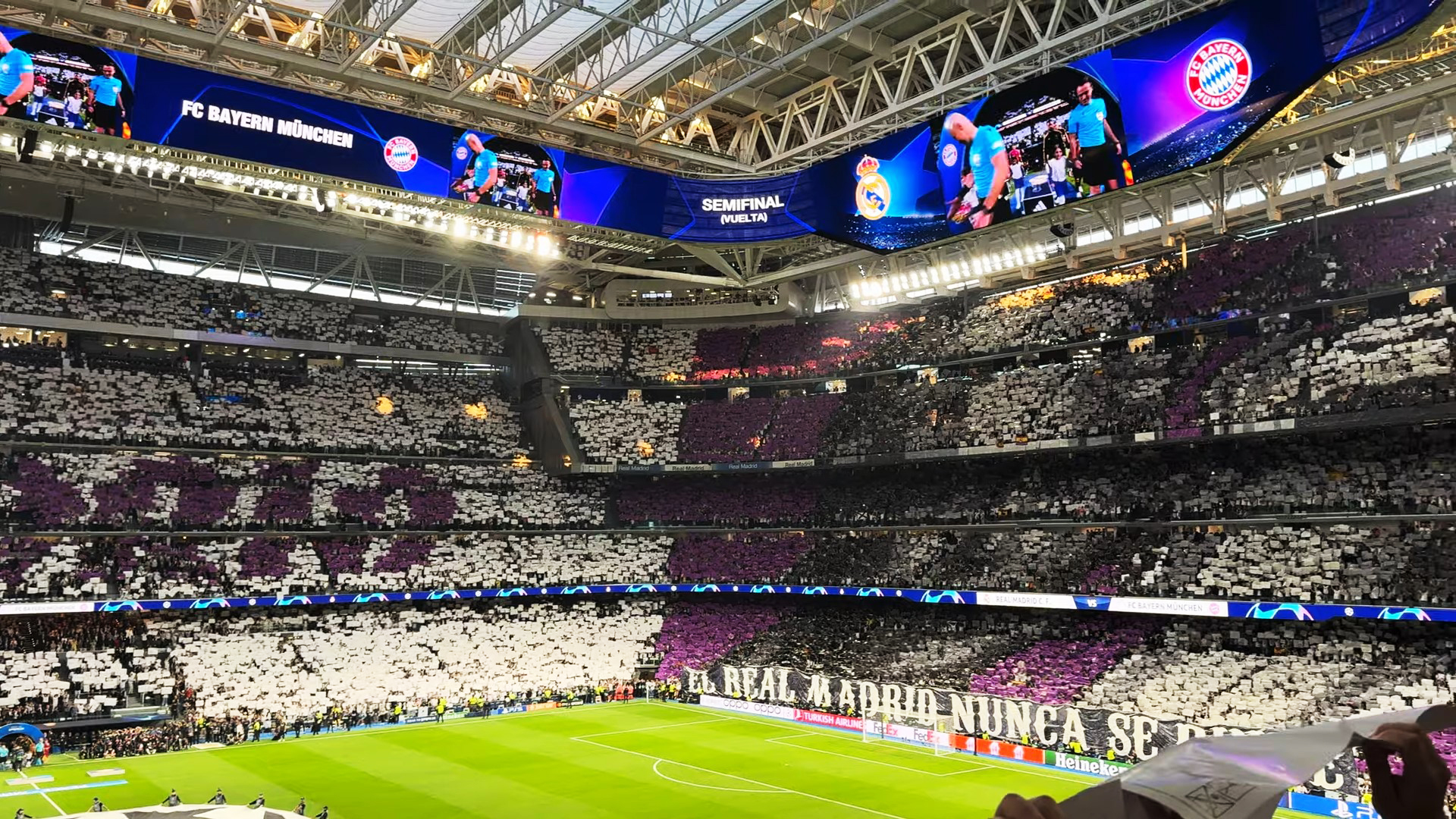 Jugadores del Real Madrid en un corrillo durante un partido importante, con el estadio iluminado de noche.