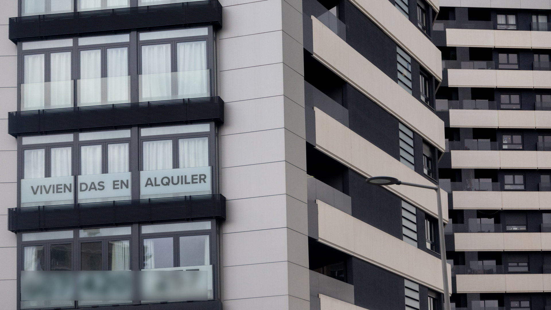 Fachada de un edificio de apartamentos en España con carteles de 