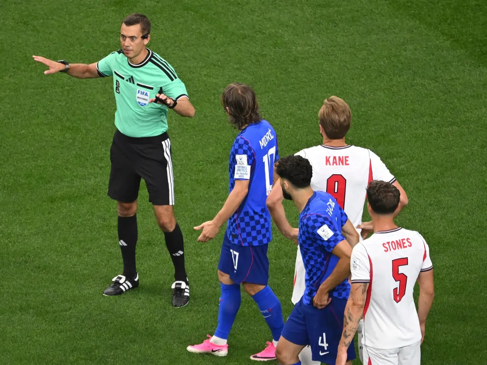 Un árbitro revisando una jugada en el monitor del VAR durante un partido de fútbol.
