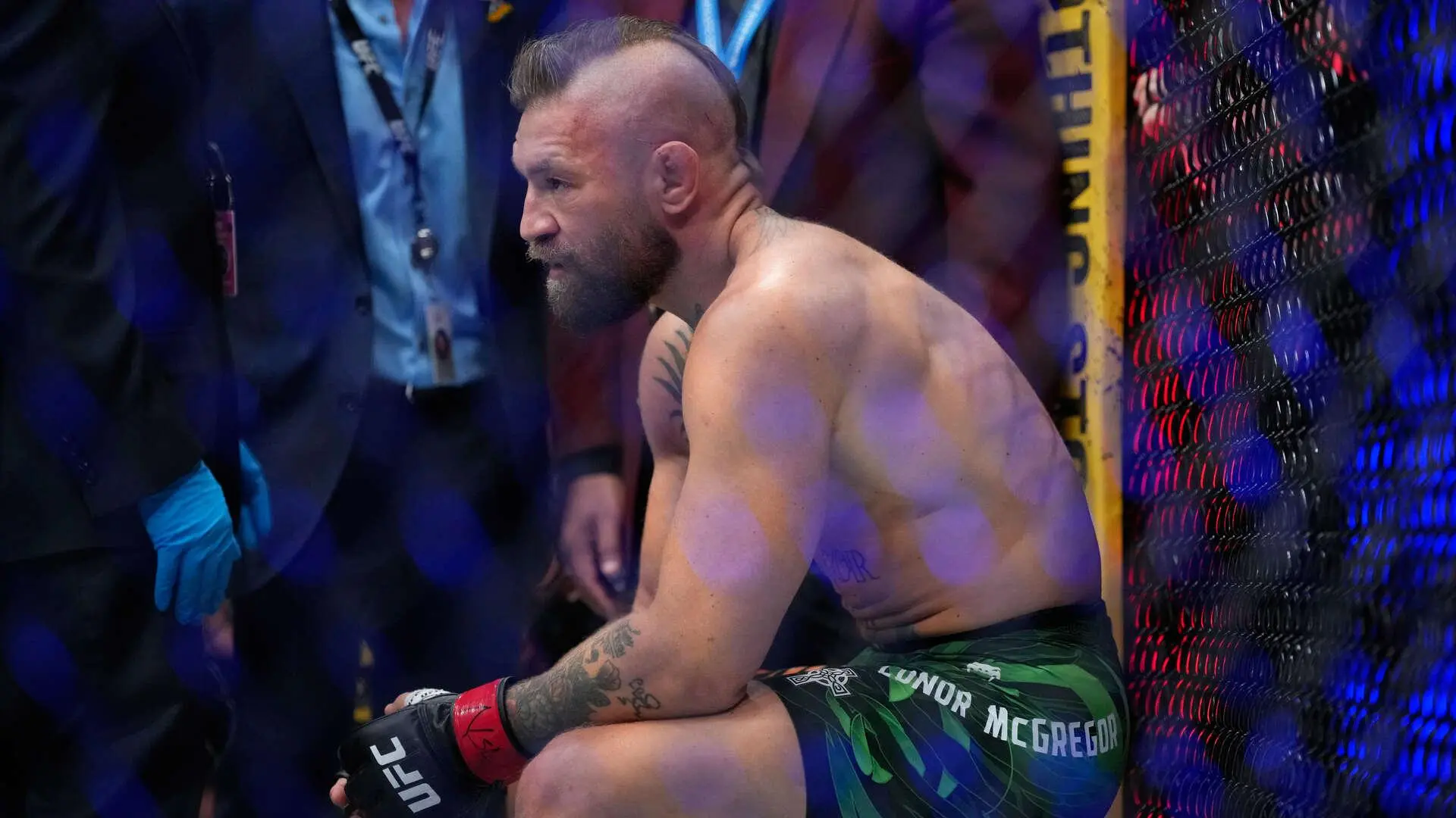 Conor McGregor visiblemente adolorido en el octágono de la UFC tras sufrir una lesión en la rodilla durante su combate contra Max Holloway.