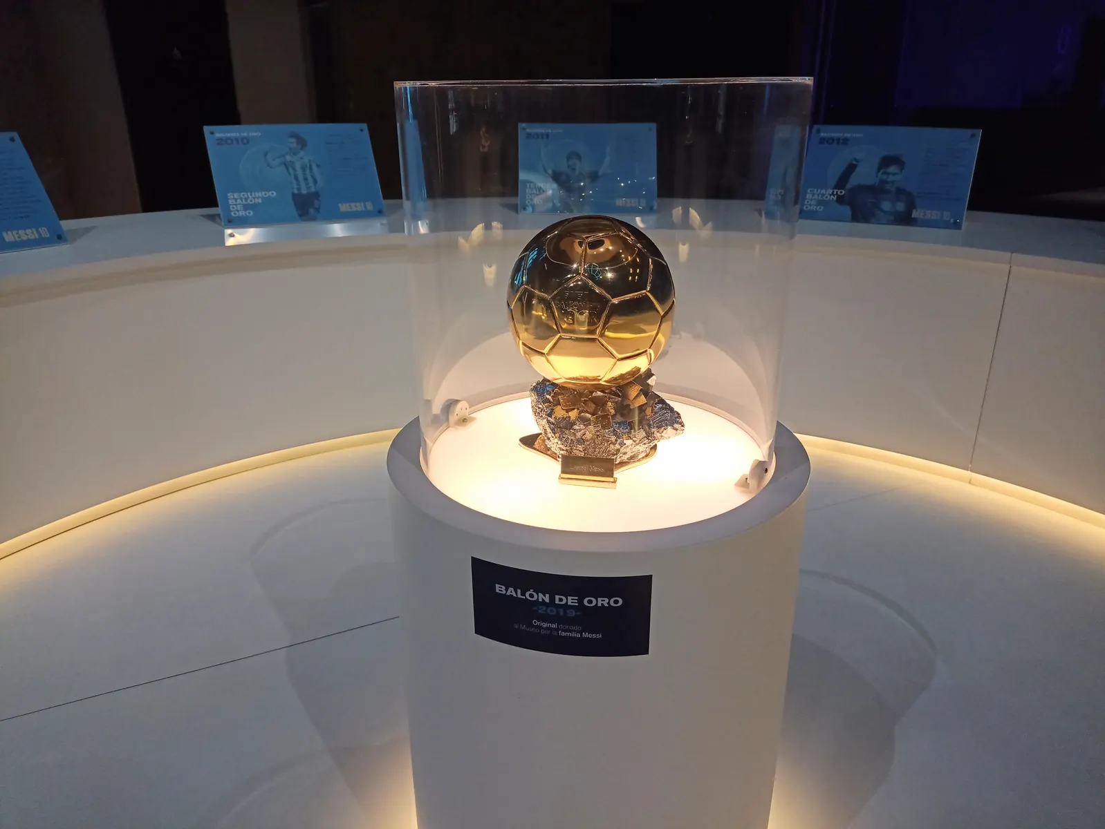 Trofeo del Balón de Oro brillando sobre un campo de fútbol